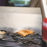 Toast on a Primus portable stove with a blurred outdoor background